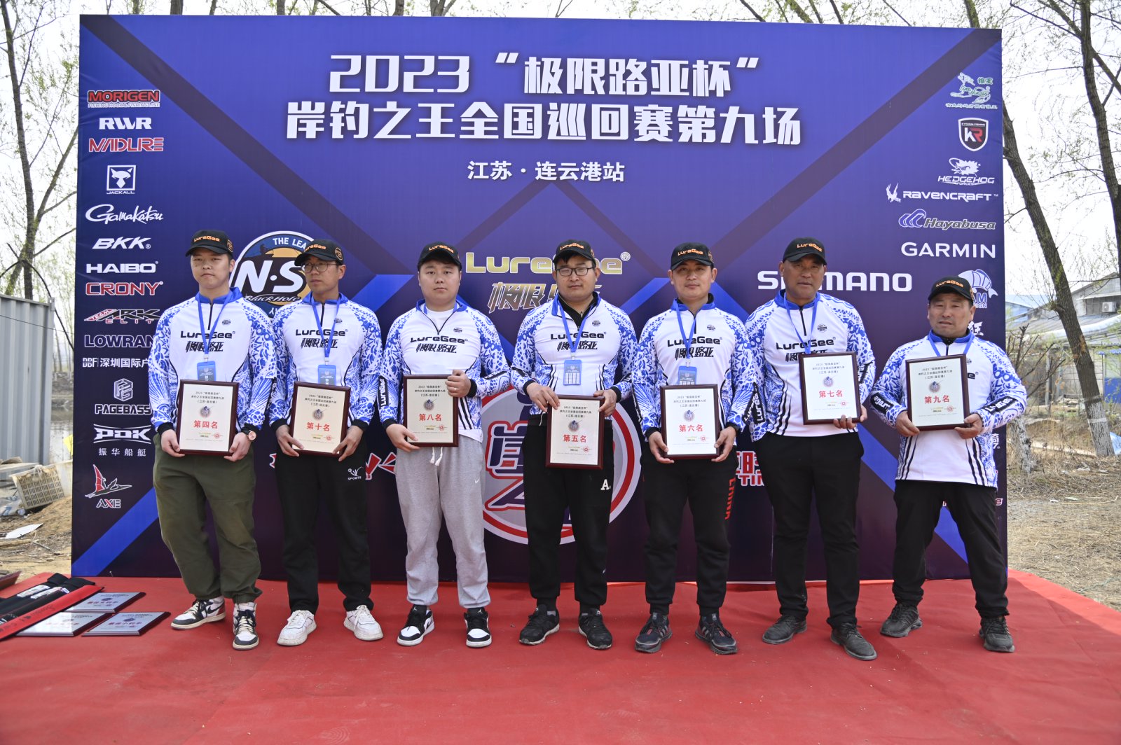 Finalists standing together in front of a tournament backdrop