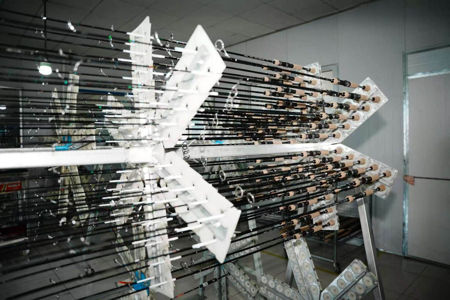 Fishing rods organized on production racks inside the workshop