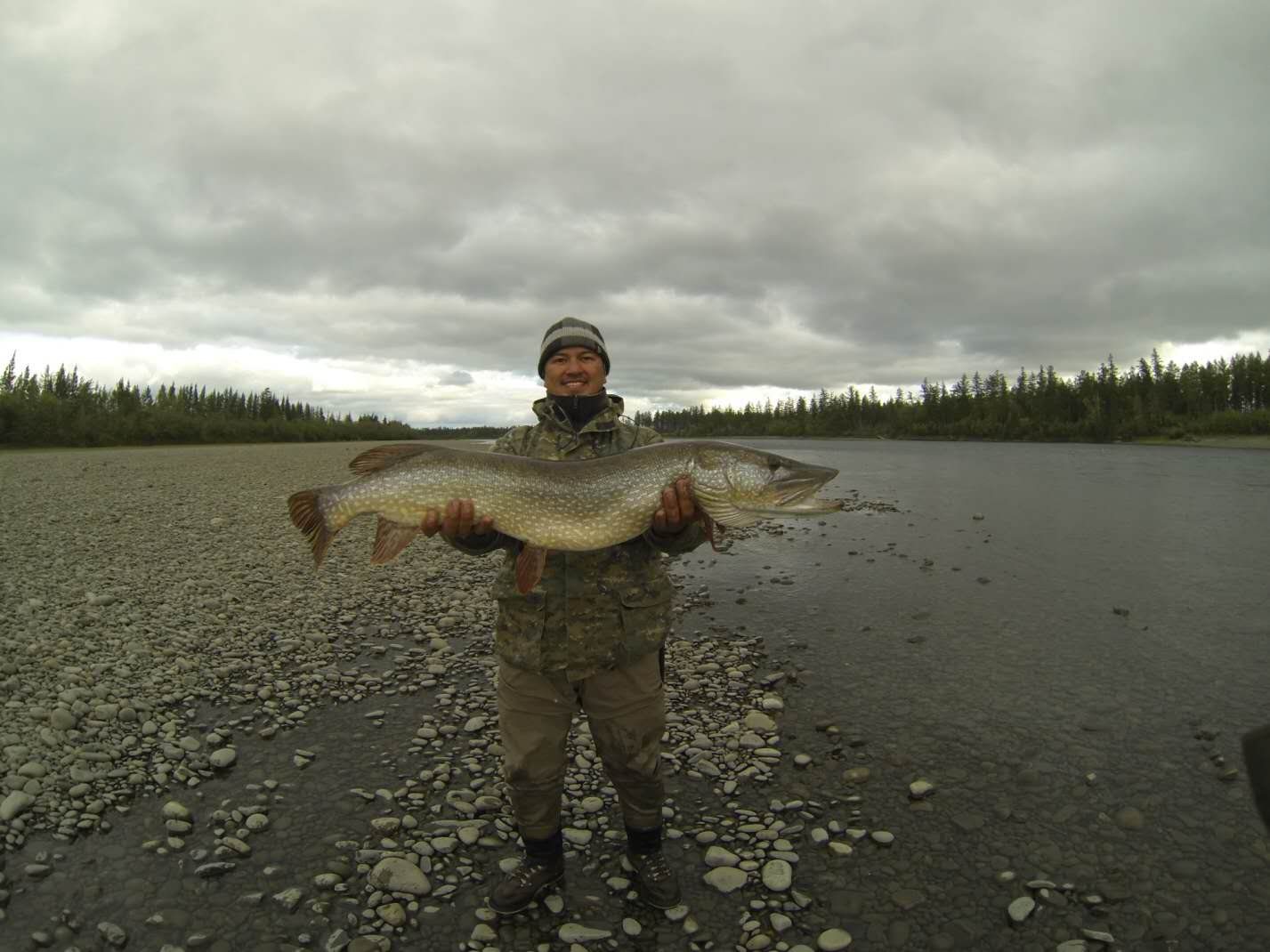 Angler standing in a river with a catch