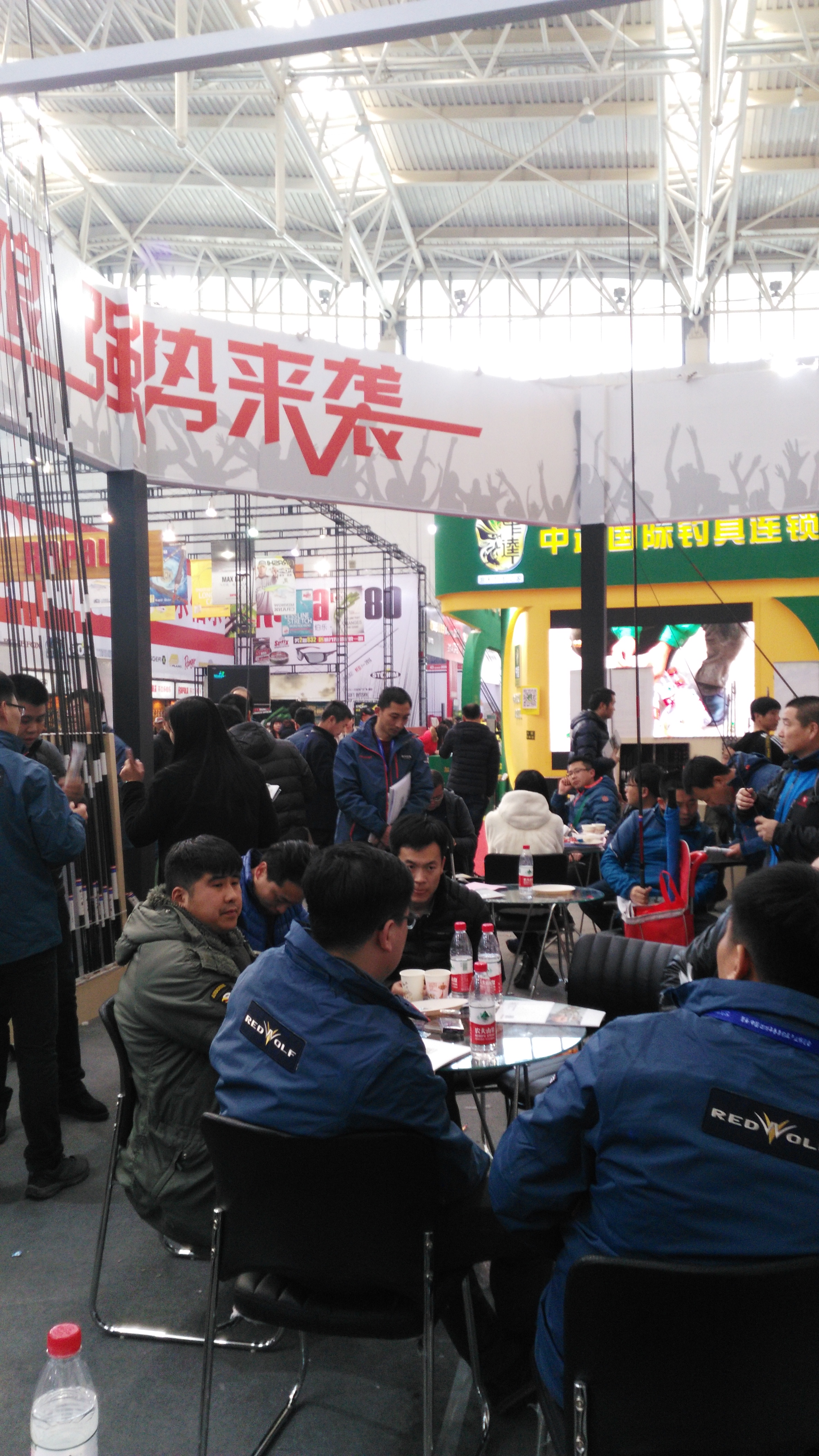 Visitors moving through a busy fishing trade hall